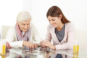 Happy grandchild playing a jigsaw puzzle with her grandmother