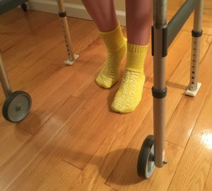 person wearing non-slip socks on hard wood floors and using a walker