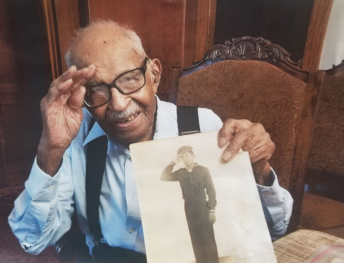 Cleveland Dyer WWII veteran saluting with his photo